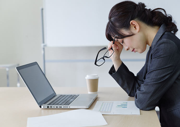 仕事で疲れている女性の様子